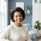 A happy diverse parent smiling in a bright modern home setting.