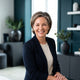 A smiling, confident woman with glowing, healthy skin in a professional headshot, representing a satisfied skincare customer.